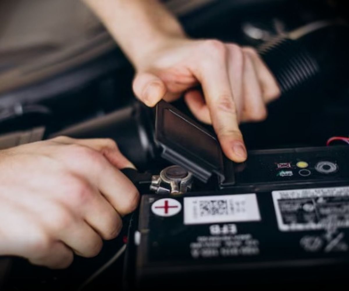 Mecânico realizando manutenção e troca de bateria automotiva